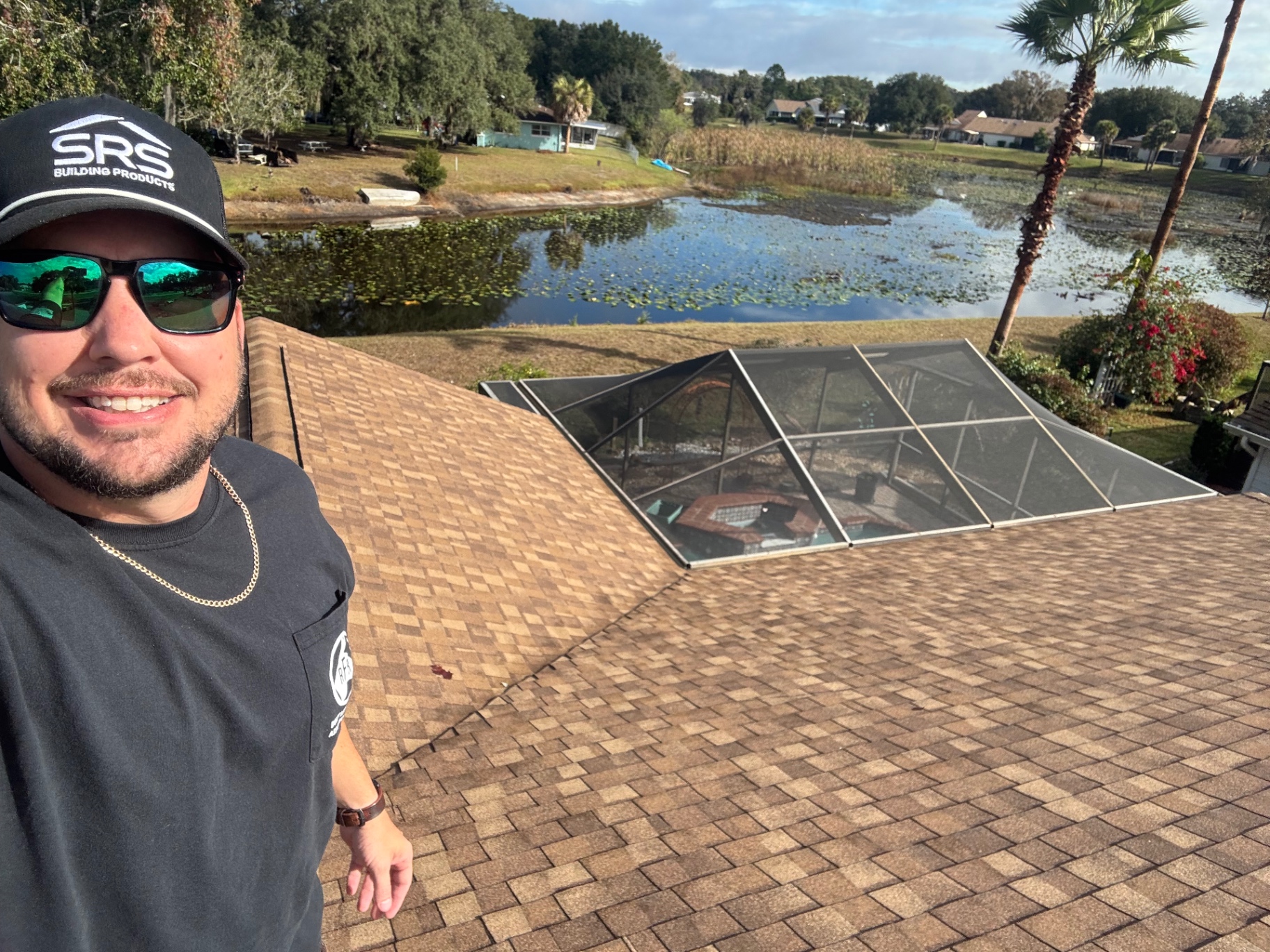 Raymond Frankart Roofing crew member on completed shingle roof overlooking Florida lake