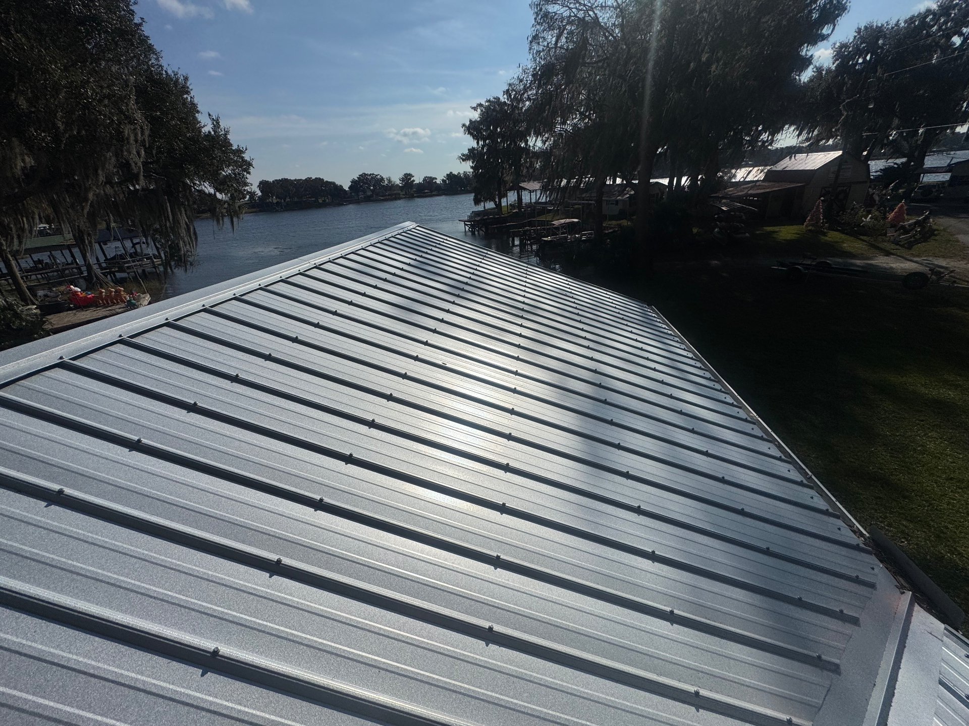 Close-up of silver standing seam metal roof overlooking lake and dock in Citrus County, FL