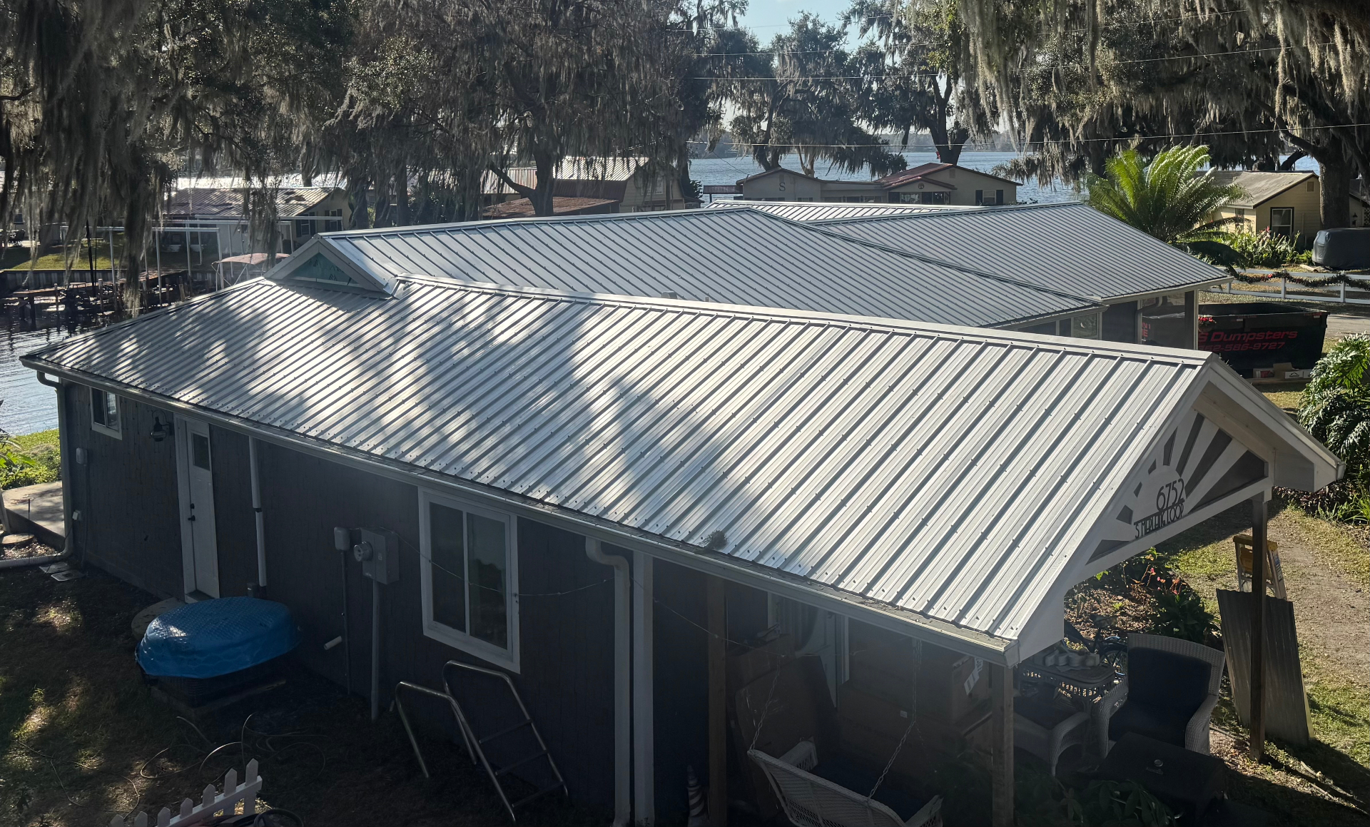Completed silver metal roof on dark lakefront cottage in Citrus County, FL