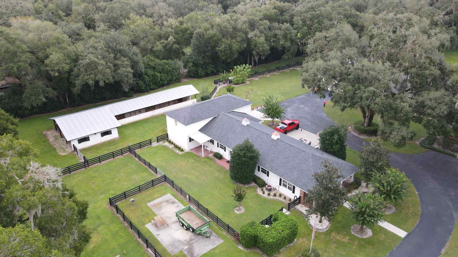 Aerial view of equestrian estate with new charcoal architectural shingle roof and white metal stable roof