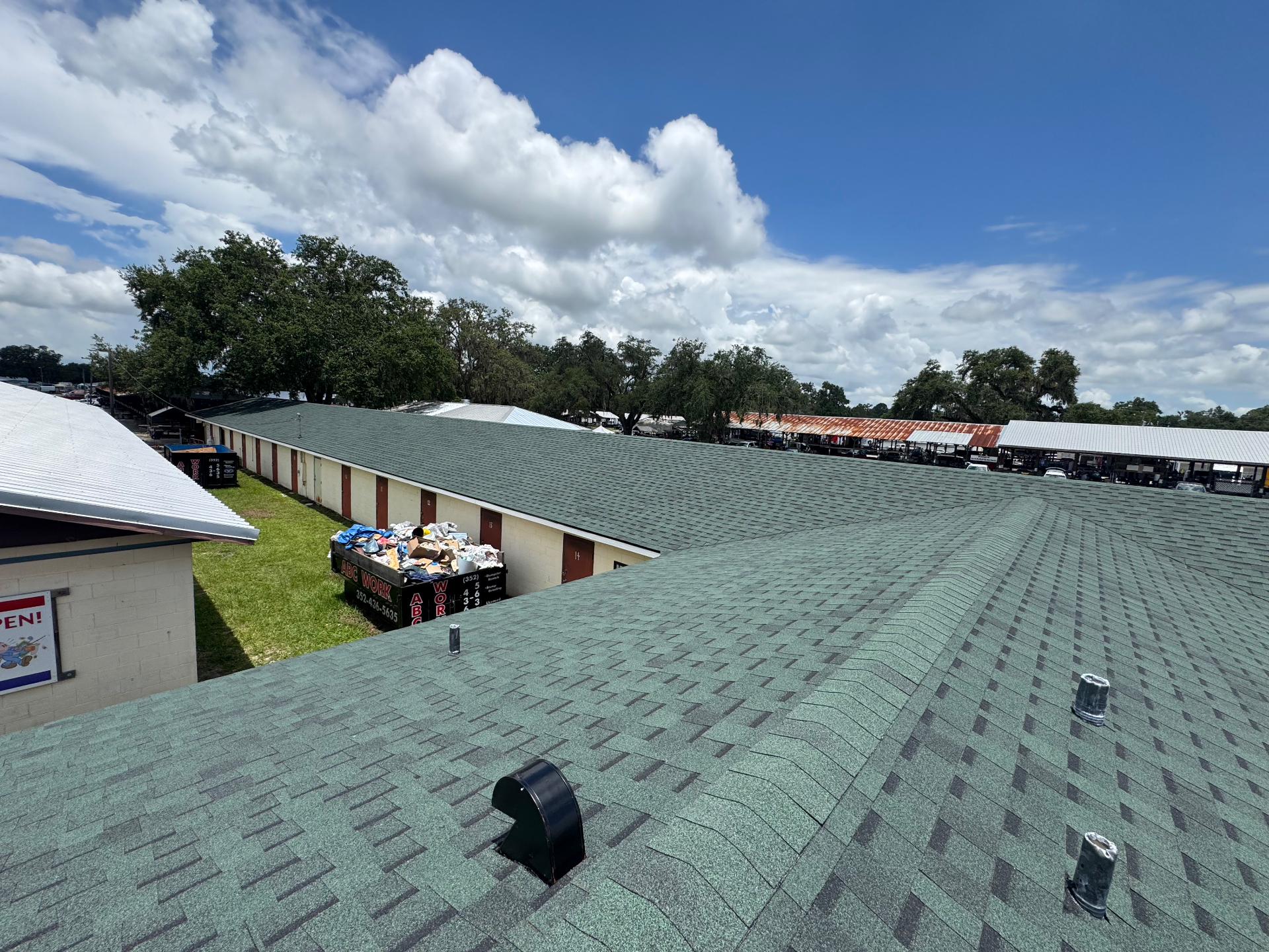 Wide view of green architectural shingle roof across long commercial building in Citrus County, FL