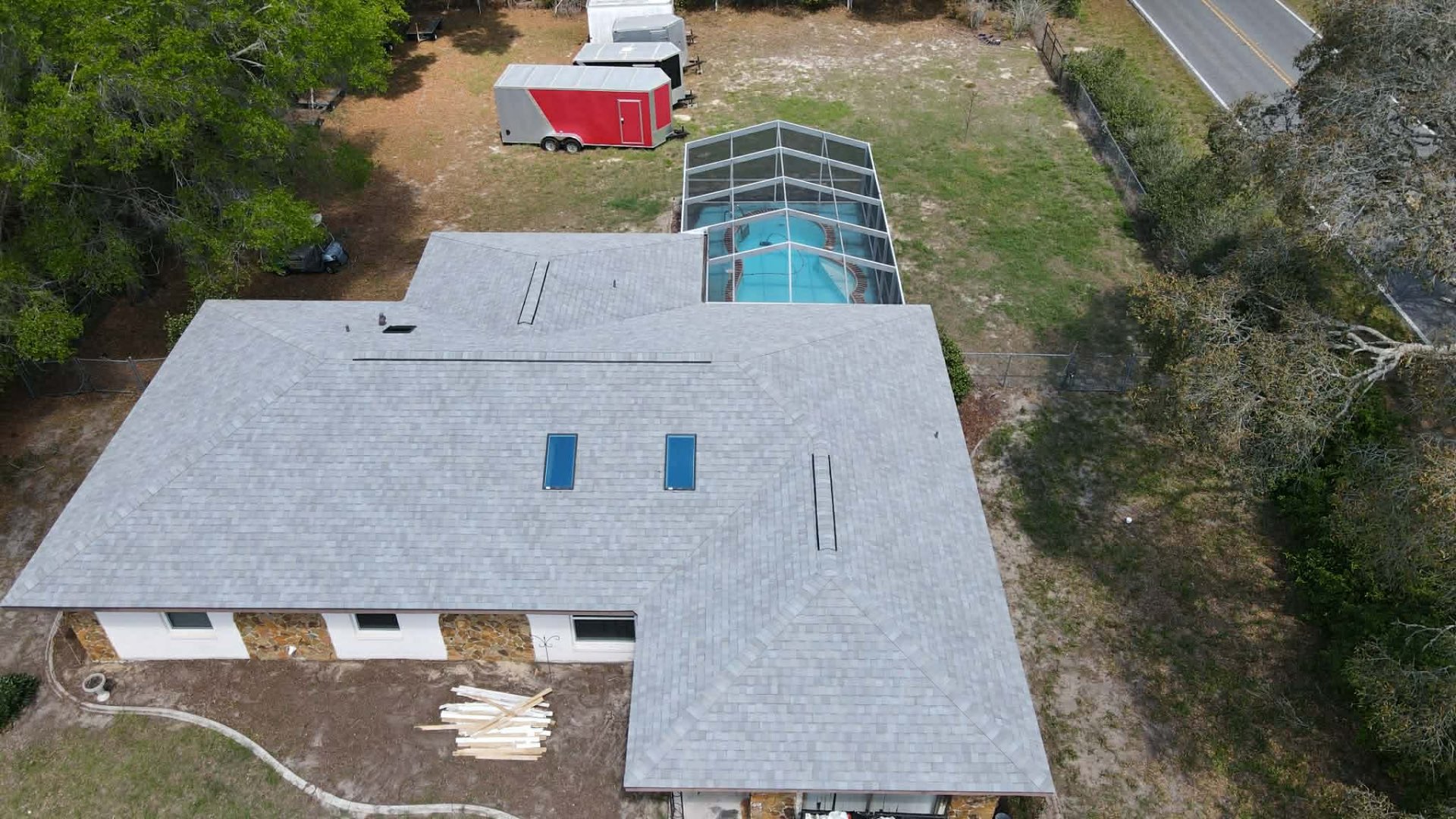 Completed shingle roof on home with screened pool enclosure