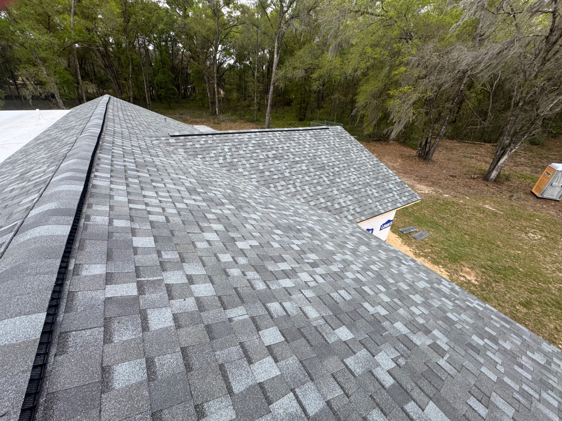 Close-up of freshly installed grey architectural shingles with ridge vent