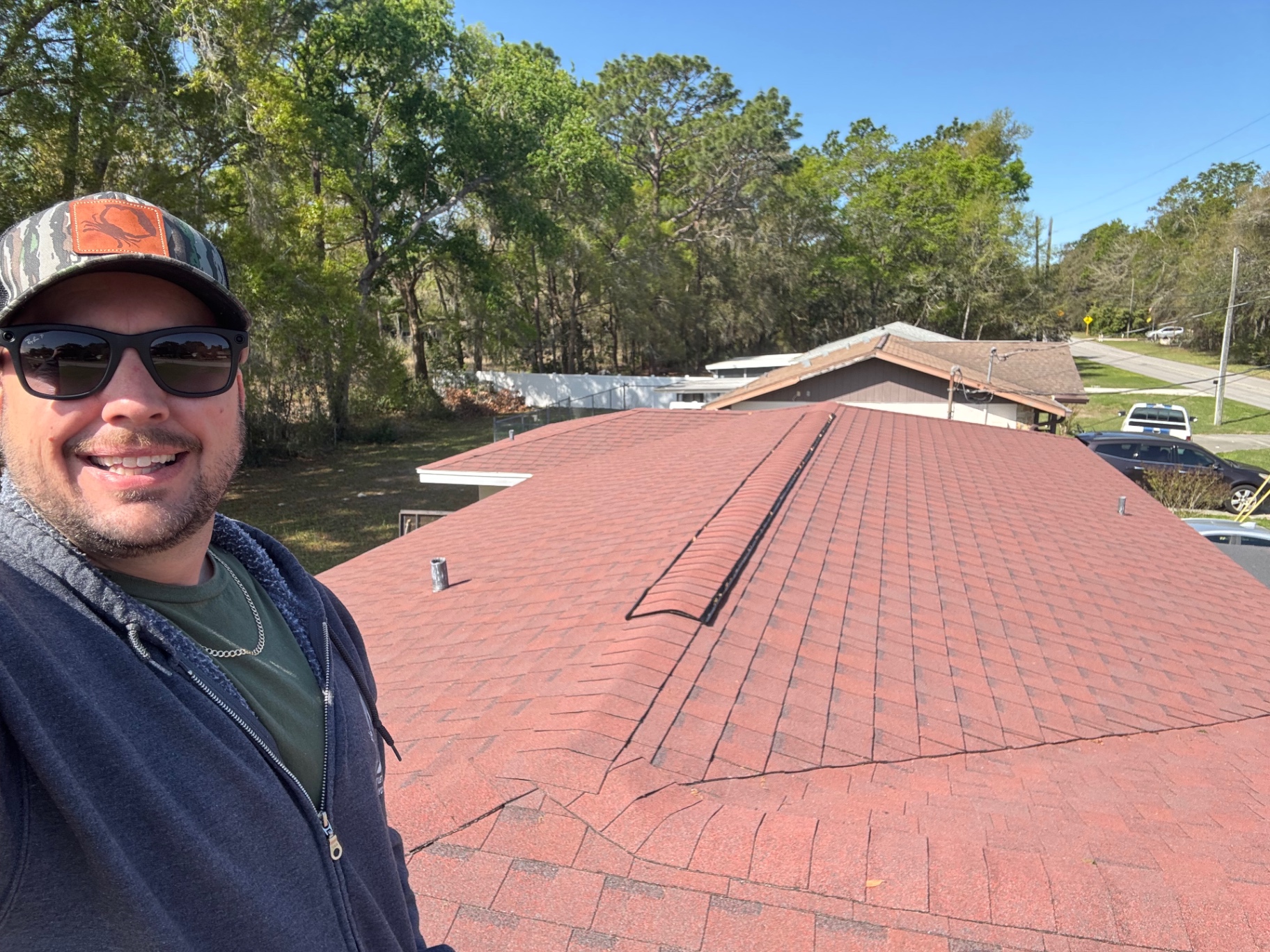 Raymond Frankart on a freshly completed red shingle roof in Citrus County, FL
